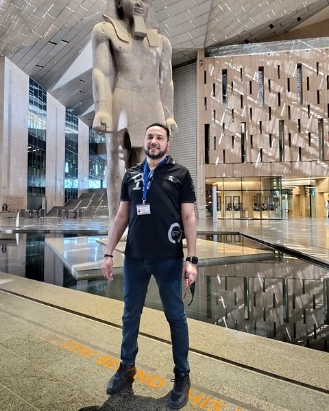 Michael Sabry in the Grand Hall of the Grand Egyptian Museum with the statue of Ramesses II